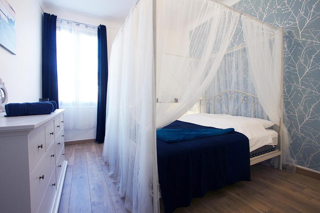 ニースにあるLe Calypso, 2-bedroom with A/C !のベッドルーム(蚊帳付きのベッド付)