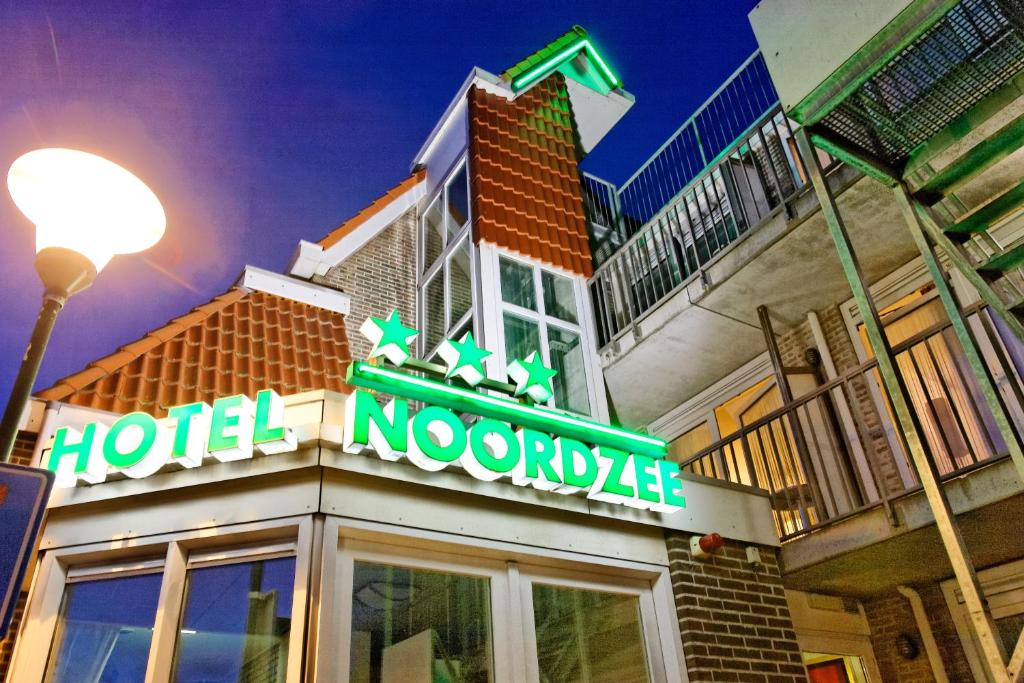 a building with a neon sign on top of it at Hotel Noordzee in Domburg