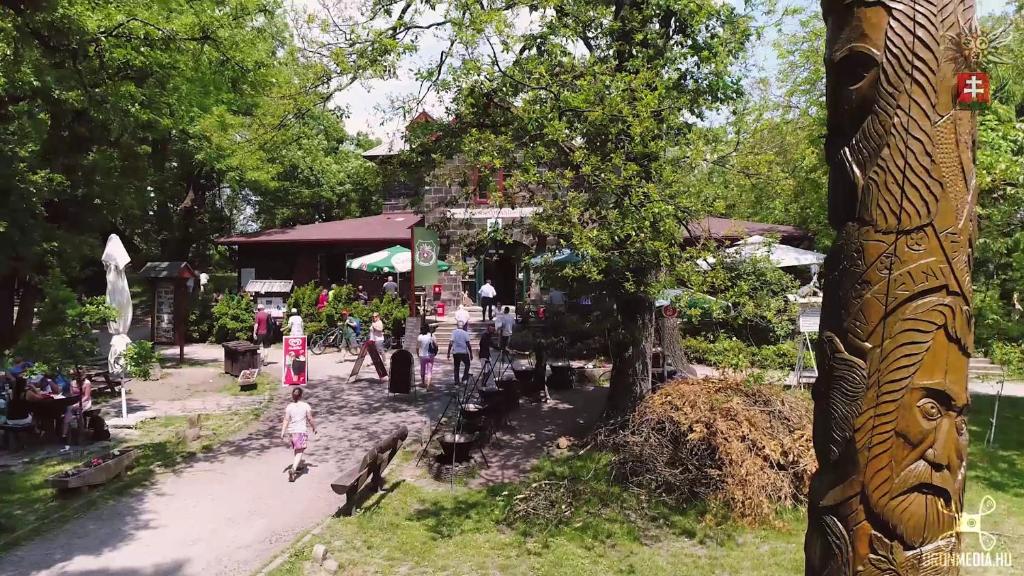 a group of people walking down a street next to a building at Báró Eötvös Loránd Menedékház in Pilisszentkereszt