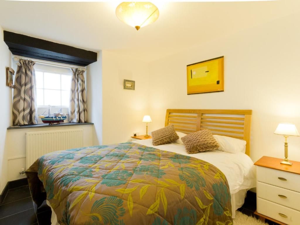 a bedroom with a large bed and a window at Museum Apartment in Looe