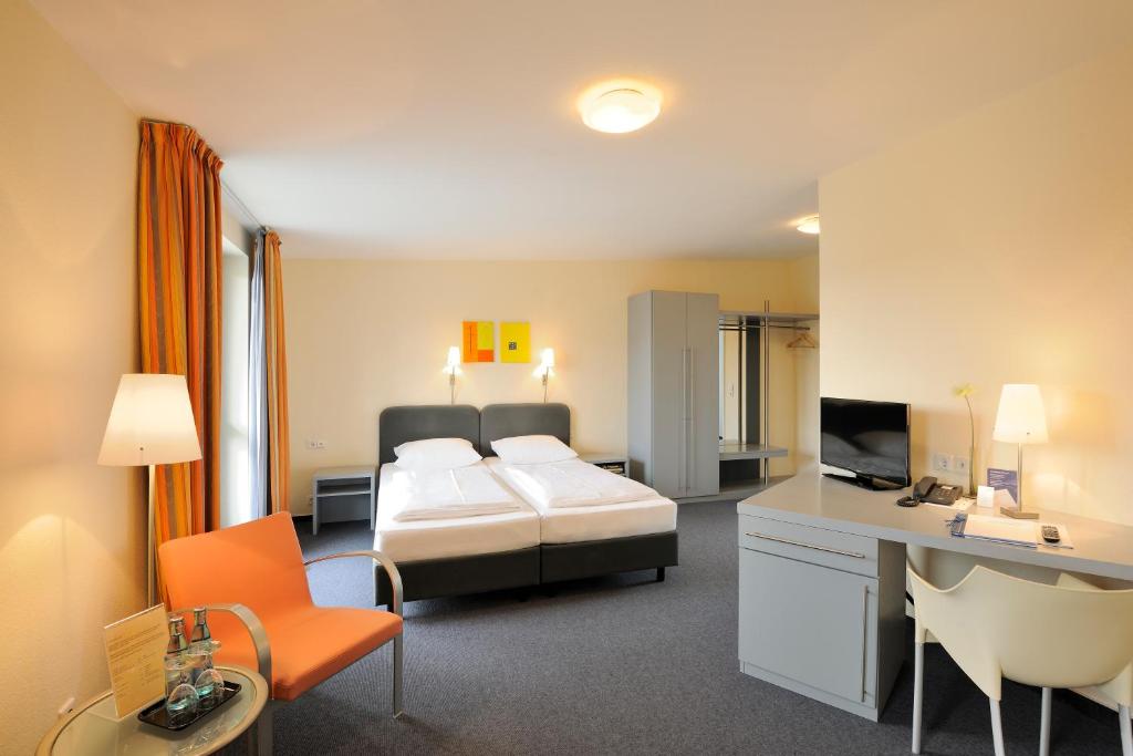 a hotel room with a bed and a desk and a room at Werkhof Hotel in Hannover