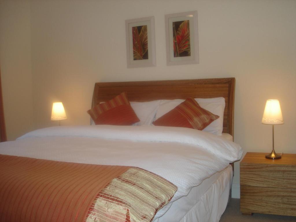 a bedroom with a large bed with two lamps at No 33 Ardmullen in Kenmare