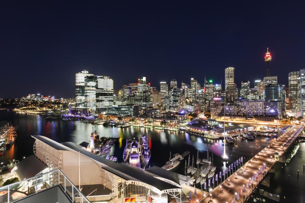 una vista de la ciudad por la noche con un puerto en 3 Bedroom Darling Harbour Apartment en Sídney