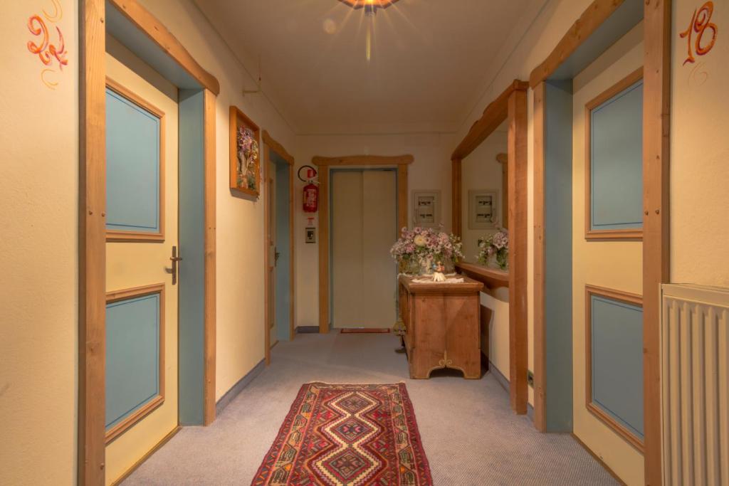 a hallway with a door and a rug at Digonera Historic Hotel B&B in Rocca Pietore