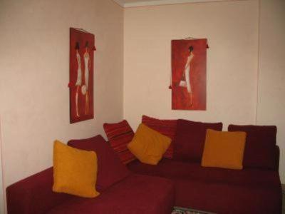 a living room with a red couch with yellow pillows at Casa Sotto La Rocca in Radicofani