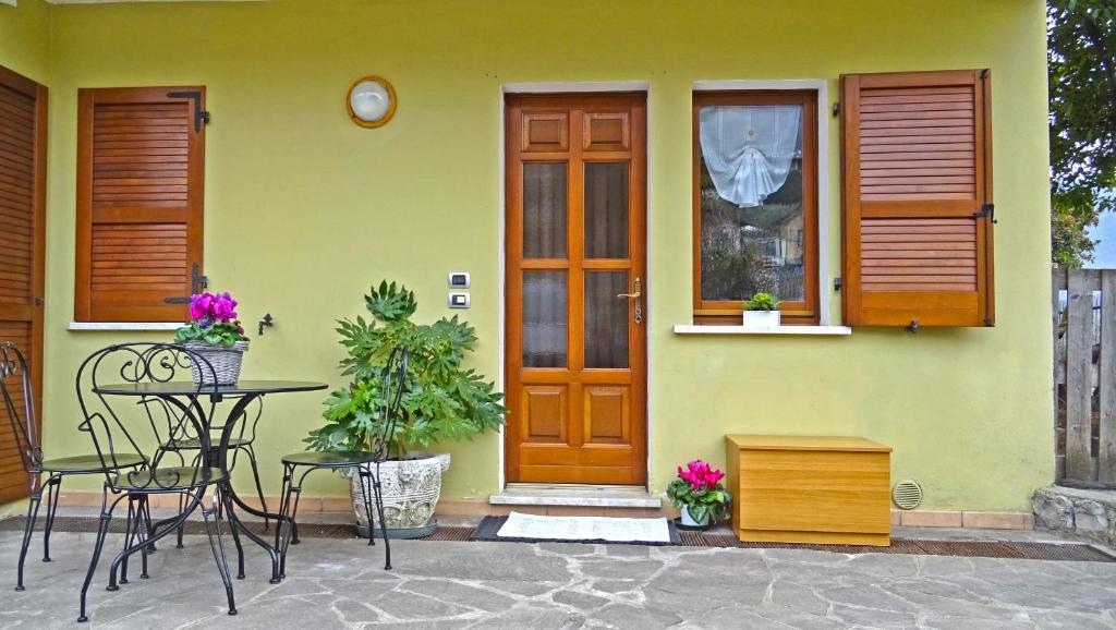 una casa verde con tavolo, sedie e porta di Casa Rosalia cozy holiday apartment by Gardadomsumea a Pieve