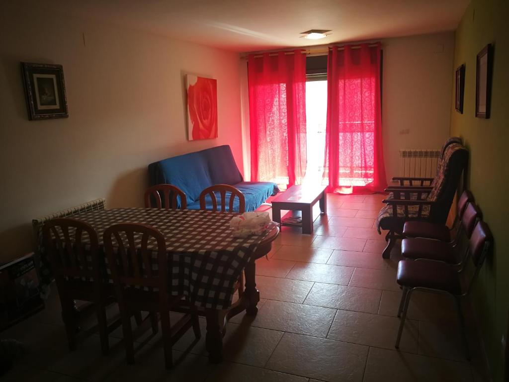 - une salle à manger avec une table, des chaises et des rideaux rouges dans l'établissement Apartamento rural Escarla 1-3, à Aren