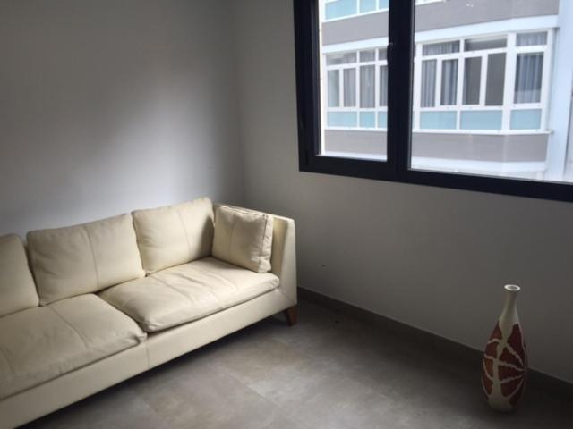 a white couch in a room with a window at Dream Canteras in Las Palmas de Gran Canaria