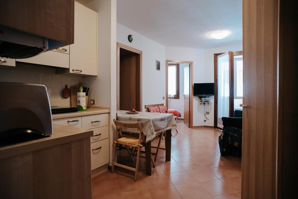 a kitchen with a table and a dining room at Val di Luce - Interno 19 in Abetone