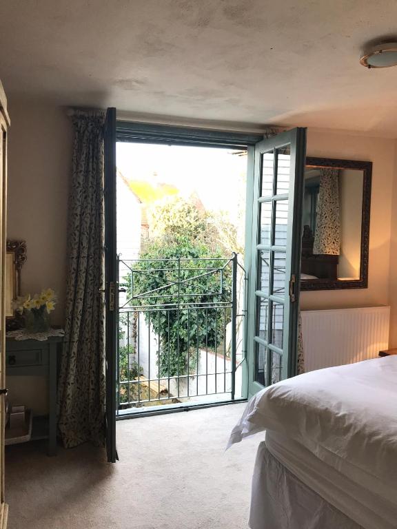 a bedroom with a door open to a balcony at The Tea House in Rye