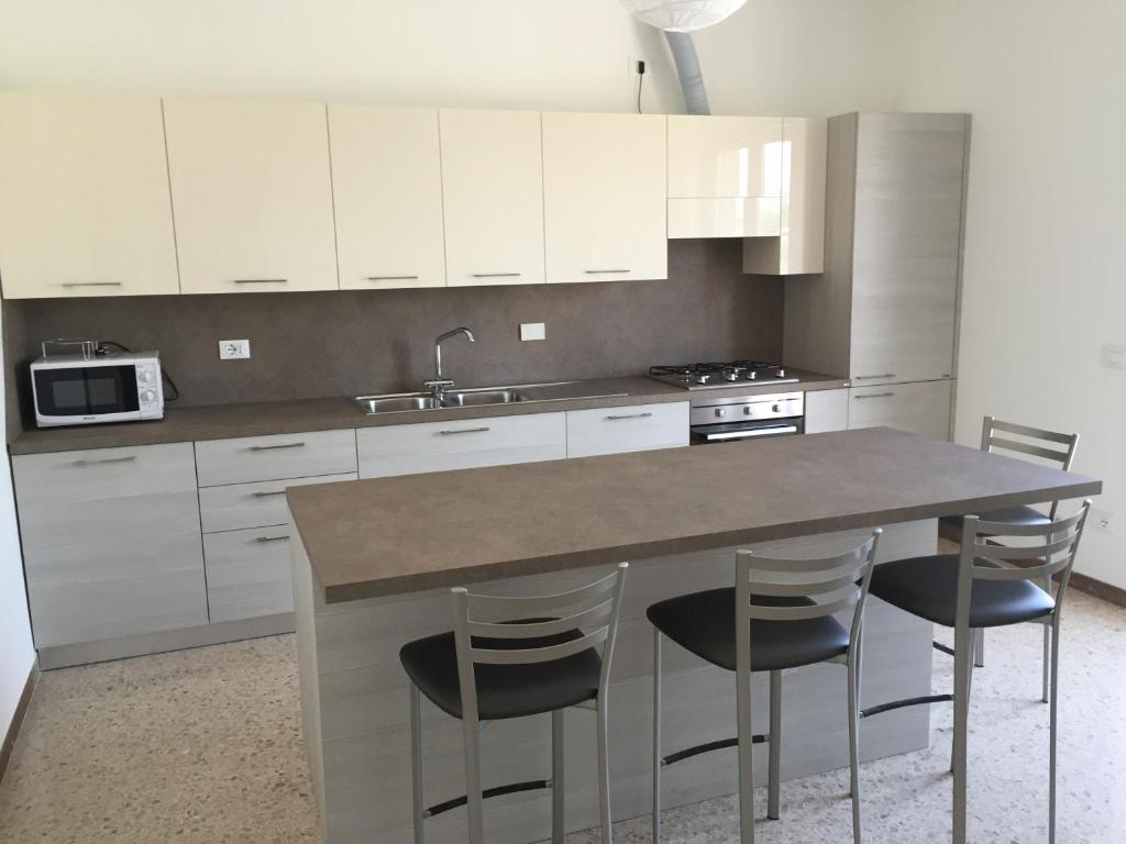 een keuken met witte kasten en een tafel met stoelen bij Comoda posizione, per 5-TERRE, PortoVenere, Lerici in La Spezia