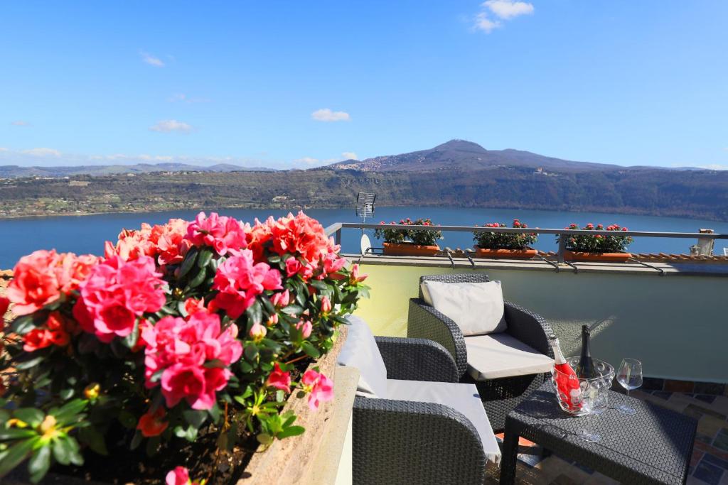 una mesa con flores en la parte superior de un balcón en Atlantis Inn Castelgandolfo, en Castel Gandolfo