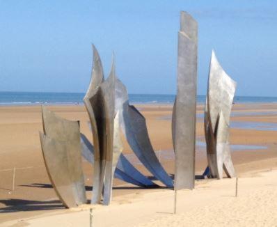a sculpture on a beach with the ocean in the background at Villa Omaha in Saint-Laurent-sur-Mer