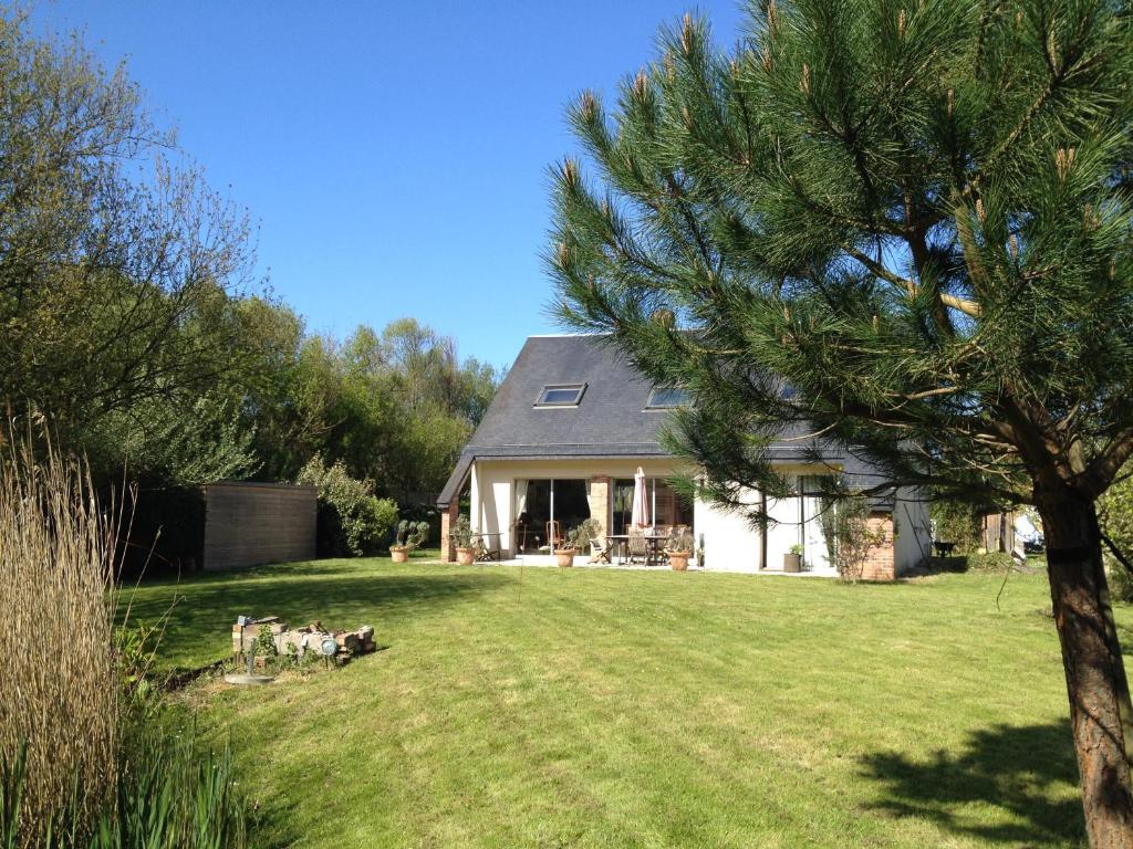 una casa con un grupo de perros en el patio en Villa Omaha, en Saint-Laurent-sur-Mer
