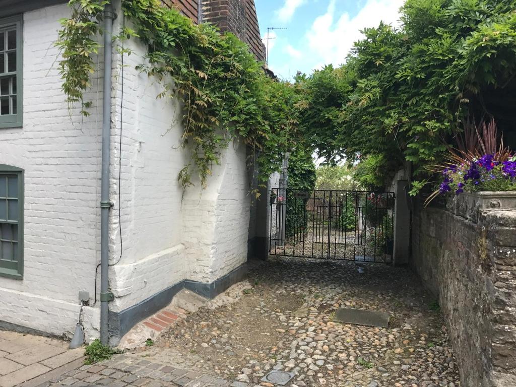 a gate to a white house with ivy on it at The Tea House in Rye