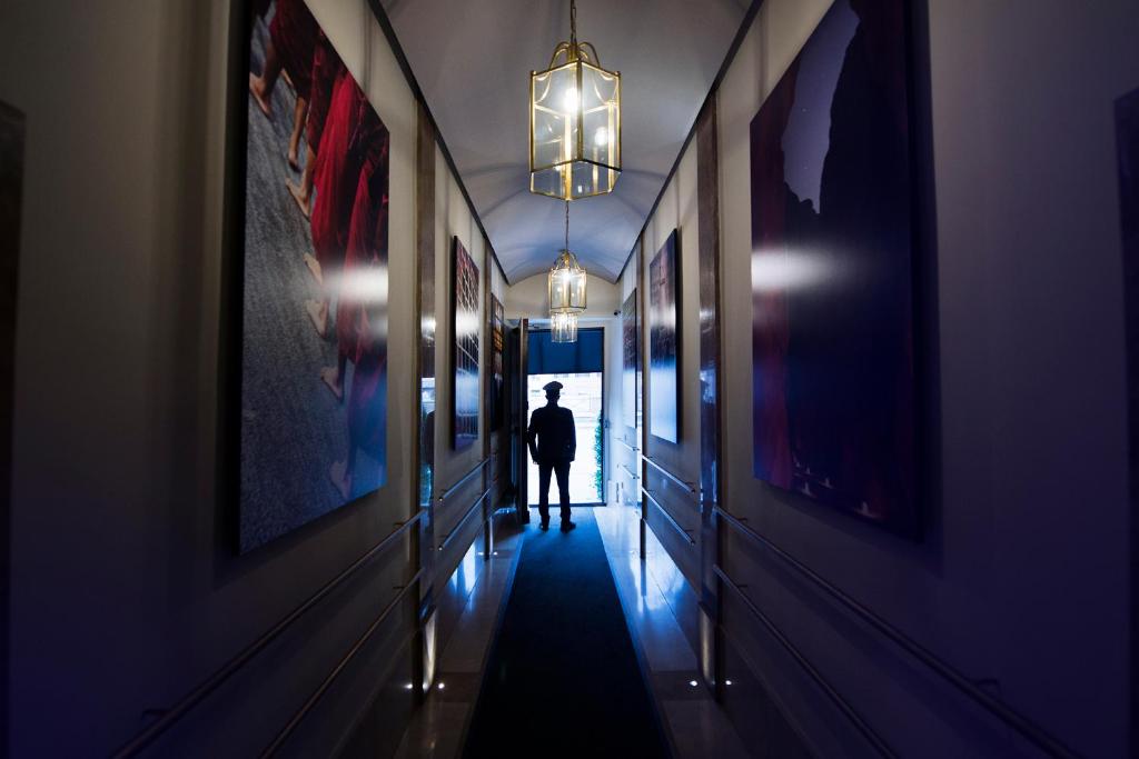 a man walking down a corridor in a hallway at Torre Argentina Relais - Residenze di Charme in Rome
