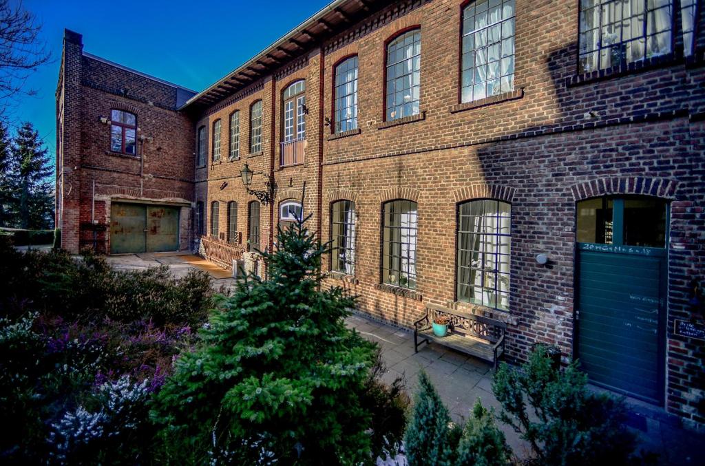 ein gro?es Backsteingeb?ude mit einer blauen Garage in der Unterkunft Carl-Kaiser-Loft I in Solingen