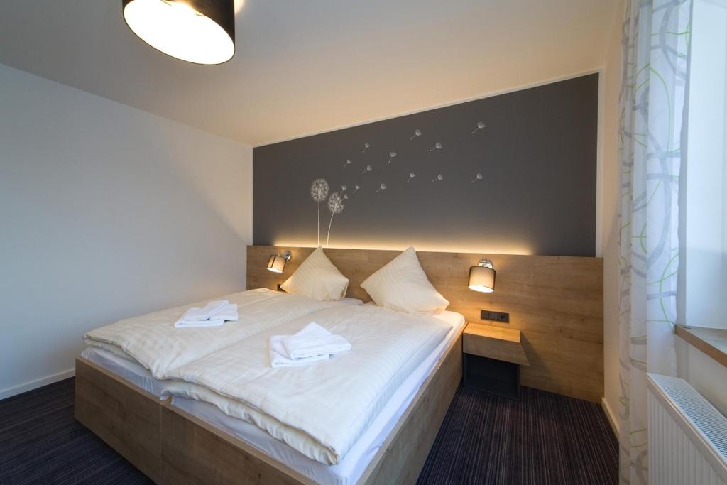 ein Schlafzimmer mit einem Bett mit zwei Handtüchern darauf in der Unterkunft Landhotel Hopster in Rheine