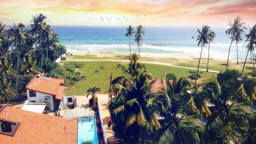 una vista aérea de una casa con palmeras y el océano en Lion's Rest, en Weligama