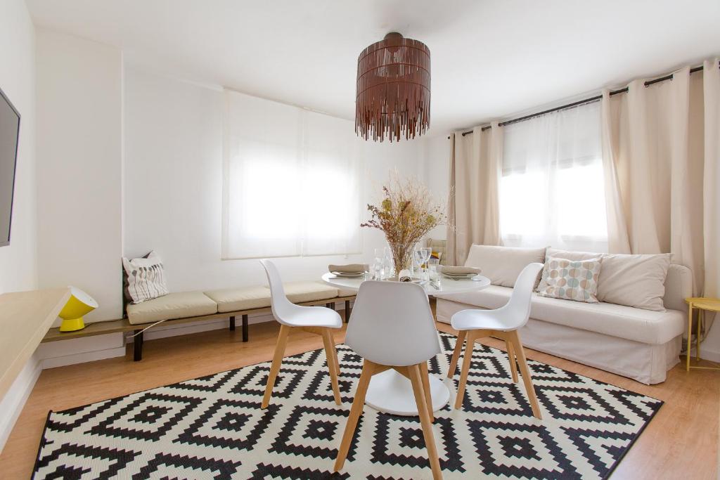 a white living room with a table and chairs at Miro in El Campello