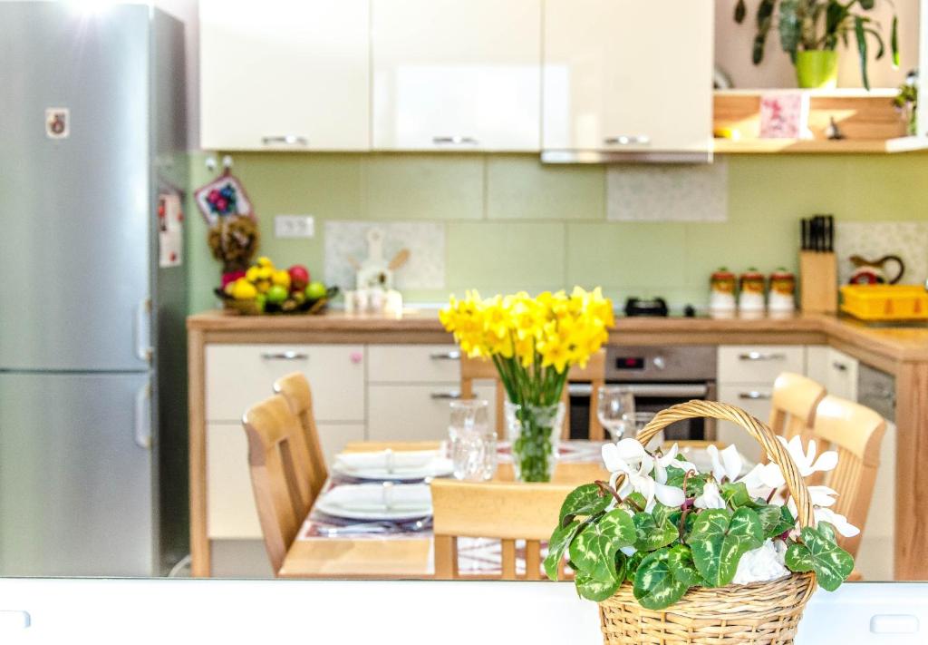 a kitchen with a table with yellow flowers in a basket at Suite by the beach in Cavtat