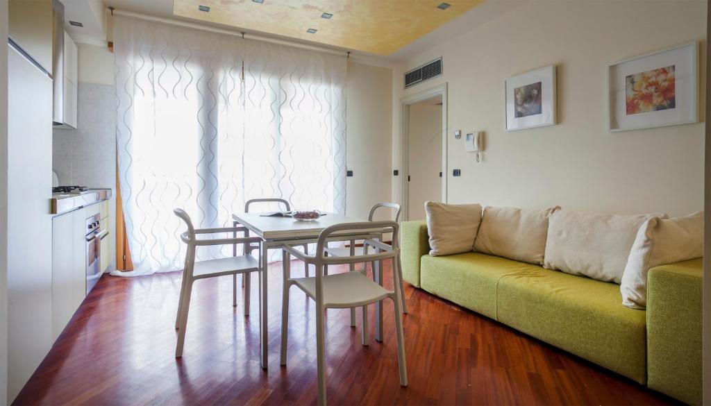 un soggiorno con tavolo e divano verde di Italianway-Spadolini a Milano