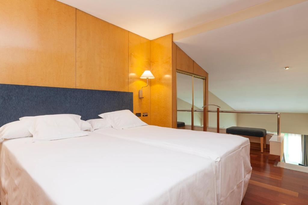 A bed or beds in a room at URH Ciutat de Mataró