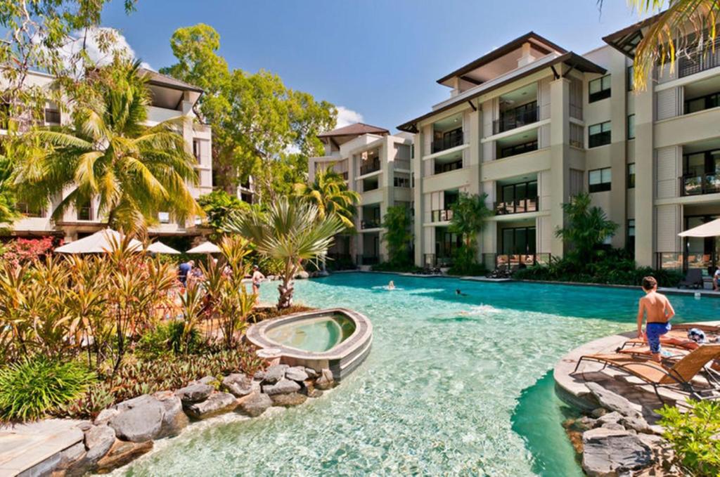 a swimming pool at a resort with a slide at Temple 221 Spacious Modern 2 Bedroom Spa Apartment Beachfront Resort in Palm Cove