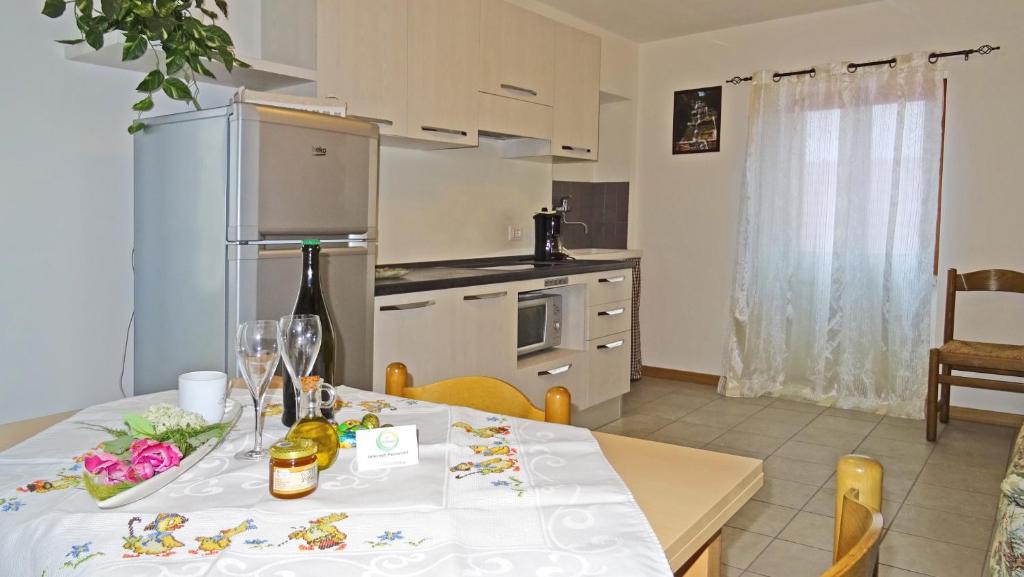 una cucina con tavolo e tovaglia bianca di La Rotonda apartments by Gardadomusmea a Tremosine Sul Garda