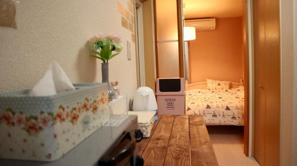 a room with a bedroom with a bed and a table at Mori de house in kobe202 in Kobe