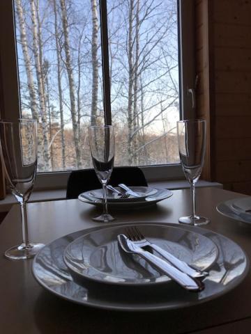 a table with a plate and two wine glasses at Tientaus 1 Apartments in Imatra