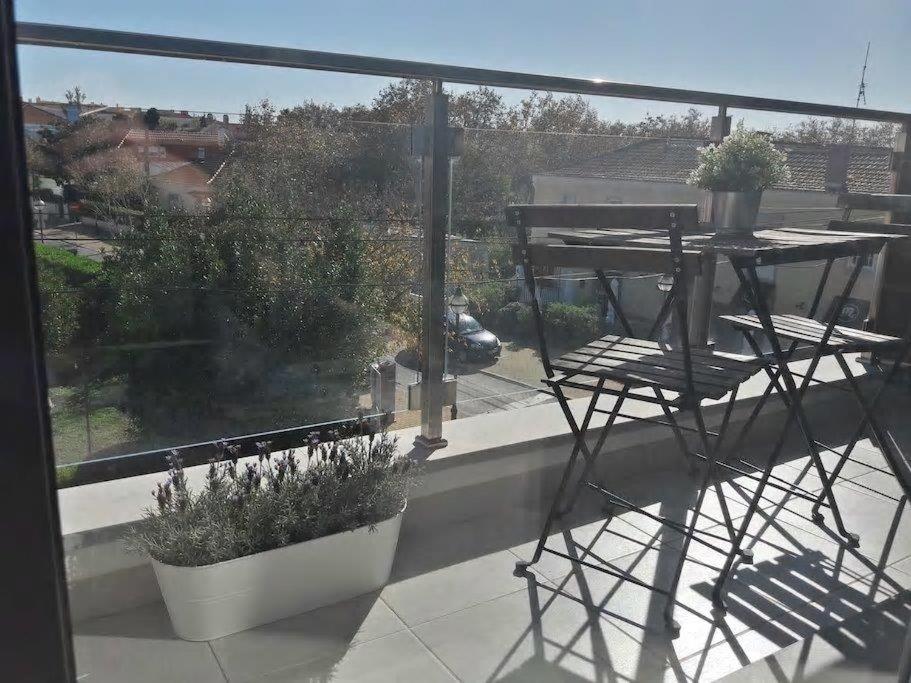 a balcony with a table and chairs and a window at modern flat in Estoril