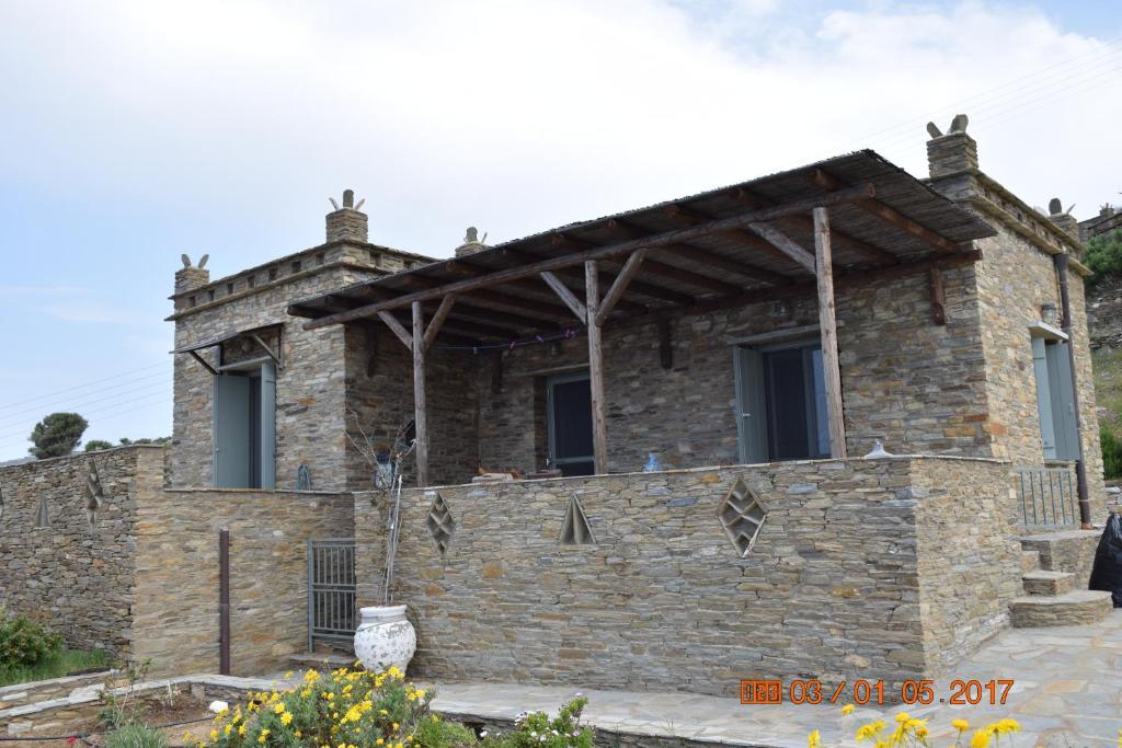 una casa in pietra con un muro di pietra di Sunrise Stone Residence ad Andro