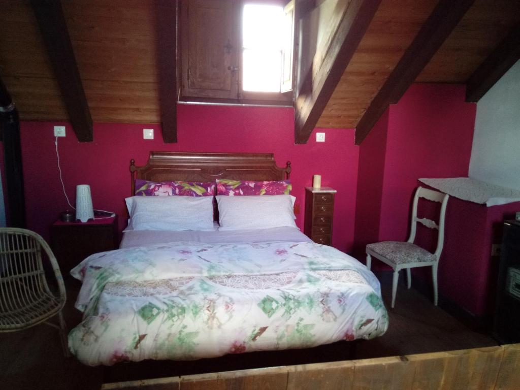 um quarto com uma cama grande e paredes cor-de-rosa em Casa del Arco em Aísa