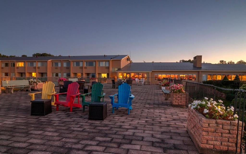 a group of colorful chairs sitting on a brick patio at Old Orchard Inn in Wolfville
