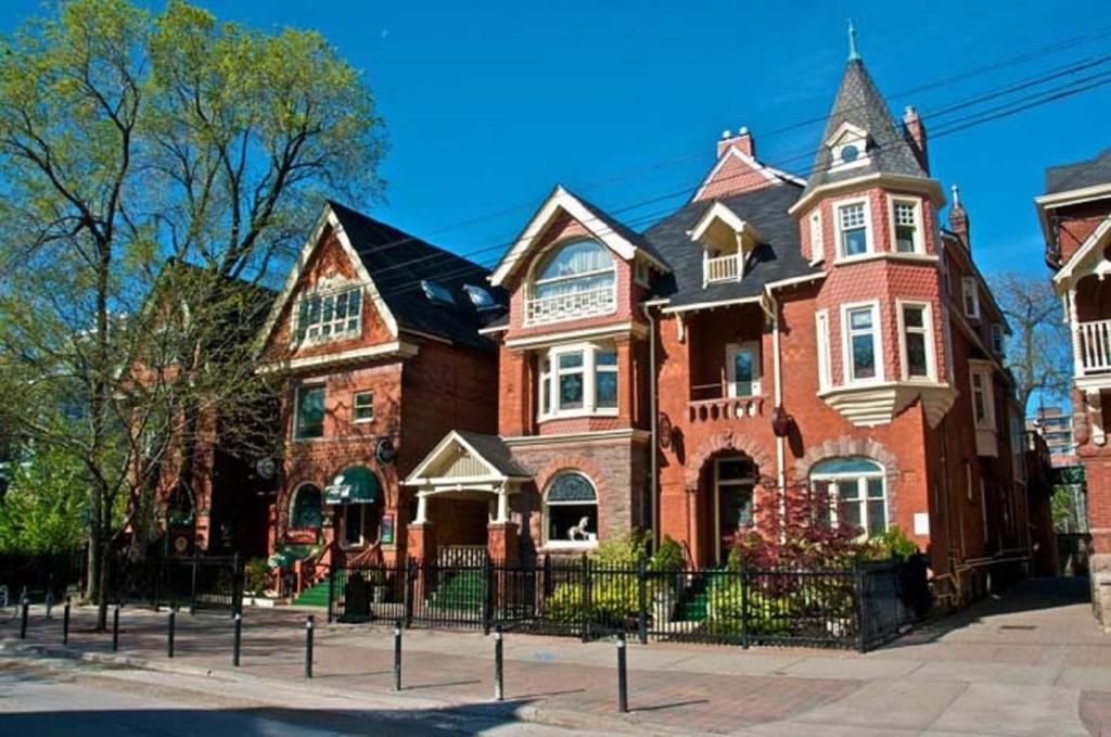 a large red brick house on a city street at Madison Manor Boutique Hotel in Toronto