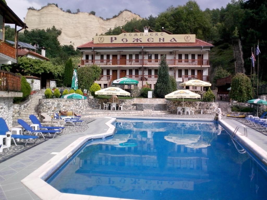 a hotel with a swimming pool in front of a building at Комплекс Рожена, хотел, хотелски комплекс Рожена in Rozhen