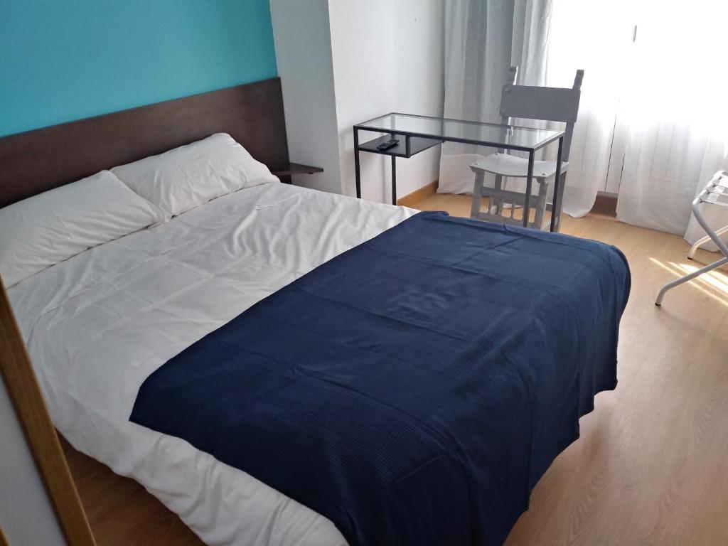 um quarto com uma cama e uma mesa de vidro em Hostal Gemi em Zamora