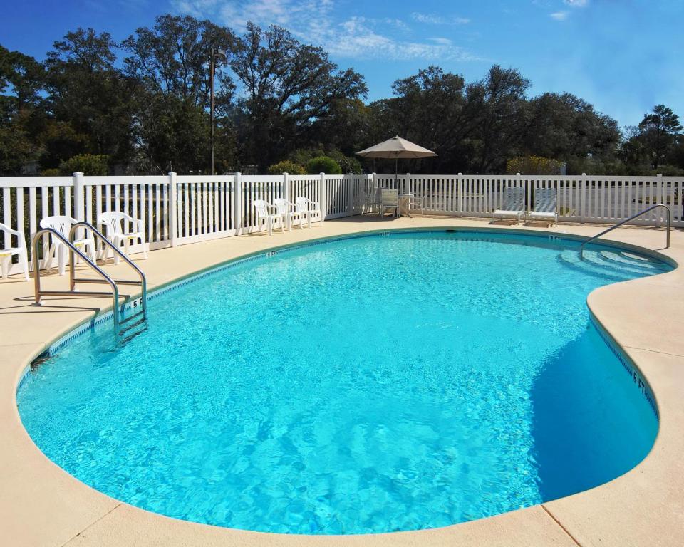 a large swimming pool with a white fence at Hathaway Inn in Panama City