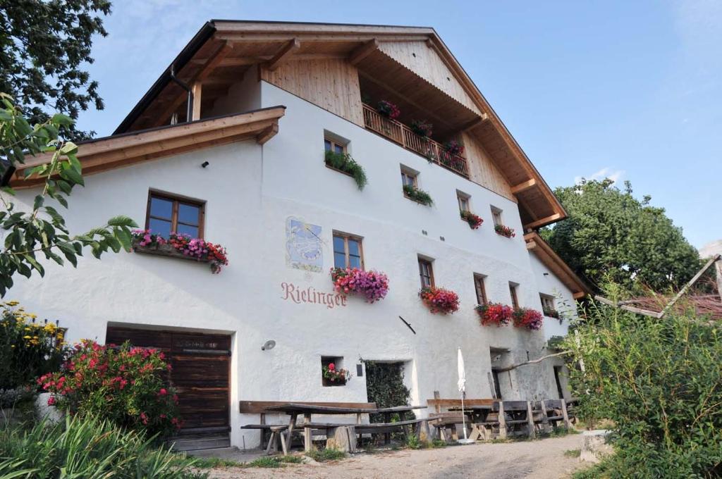 a white building with flowers on the windows at Rielingerhof in Collalbo