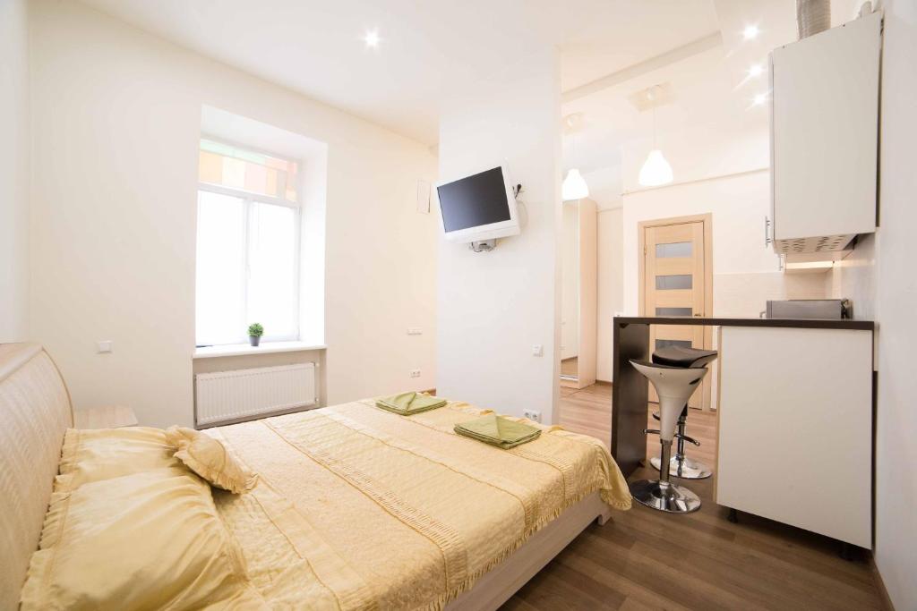 - une chambre blanche avec un lit et un bureau dans l'établissement Chornovola 11 Apartment Lviv Centre, à Lviv