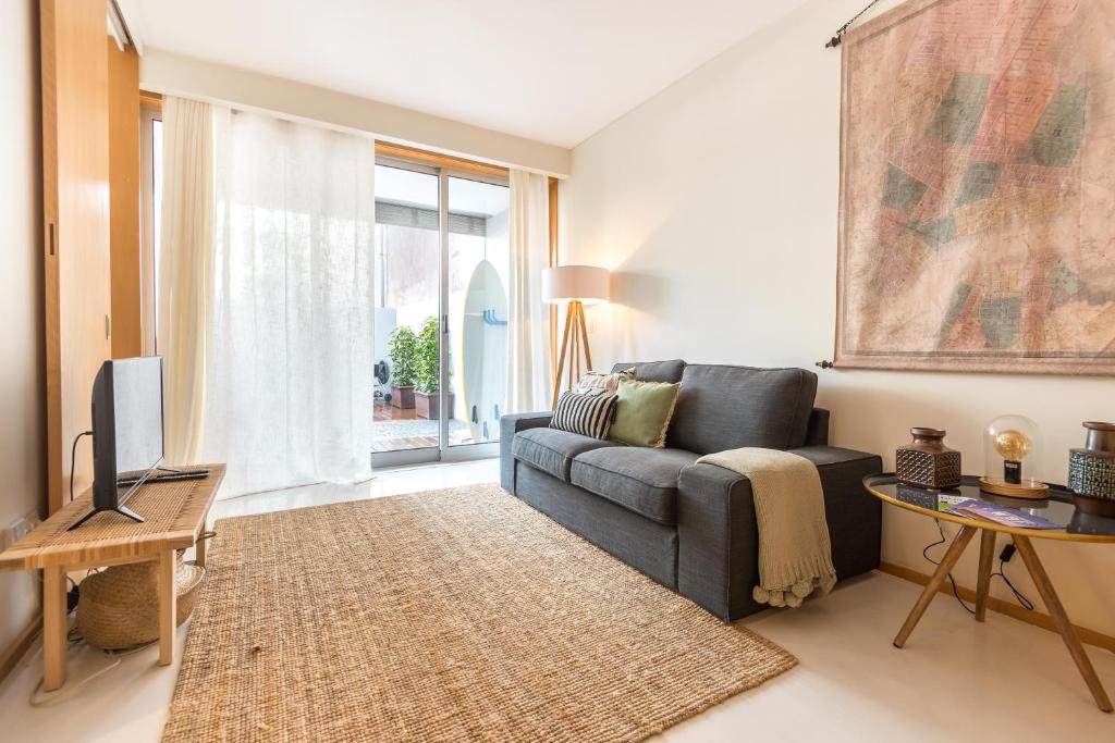 sala de estar con sofá y TV en By the Sea Apartment • Terrace · Wifi · Netflix, en Matosinhos