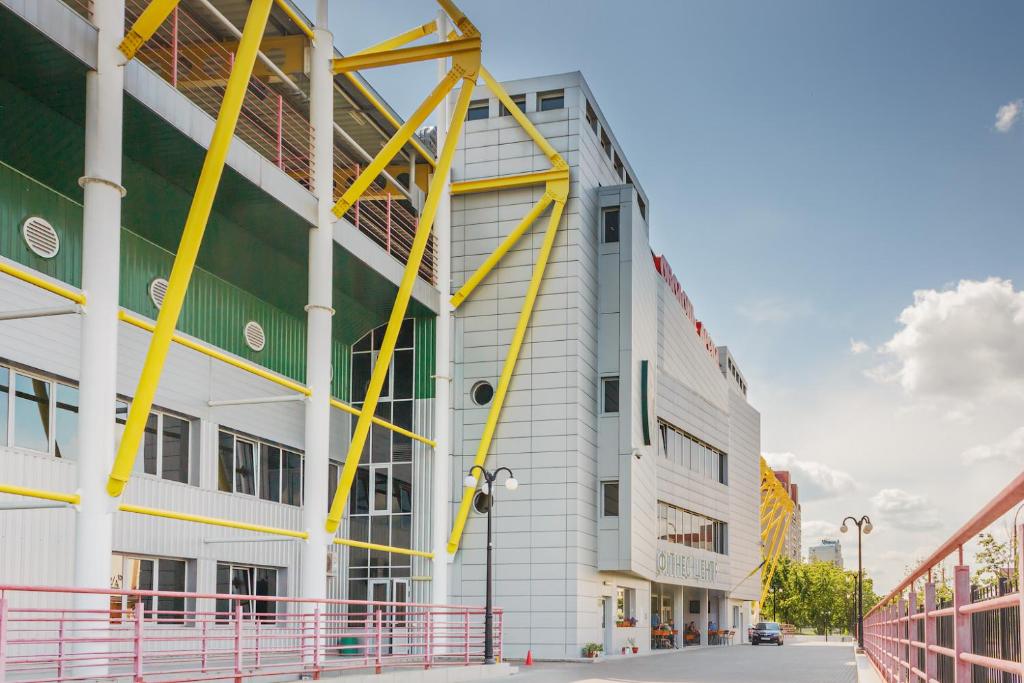 キーウにあるHotel Obolon-Arenaの黄色のアクセントが特徴の大きな白い建物