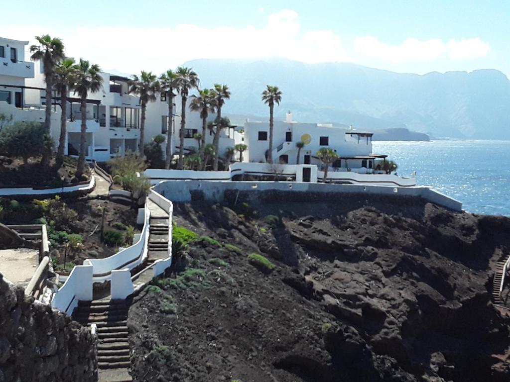 a view of a villa with the ocean at Faro de sardina Apartment in Sardina