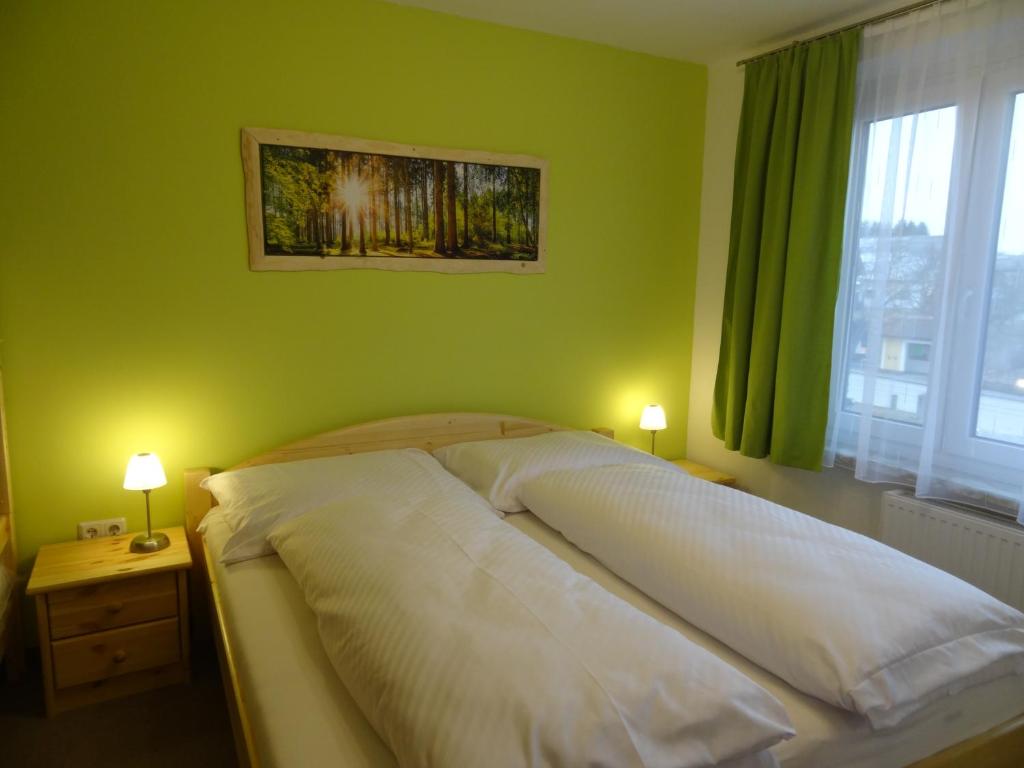 a bed in a bedroom with two lamps on tables at Nordwaldfarm in Waidhofen an der Thaya