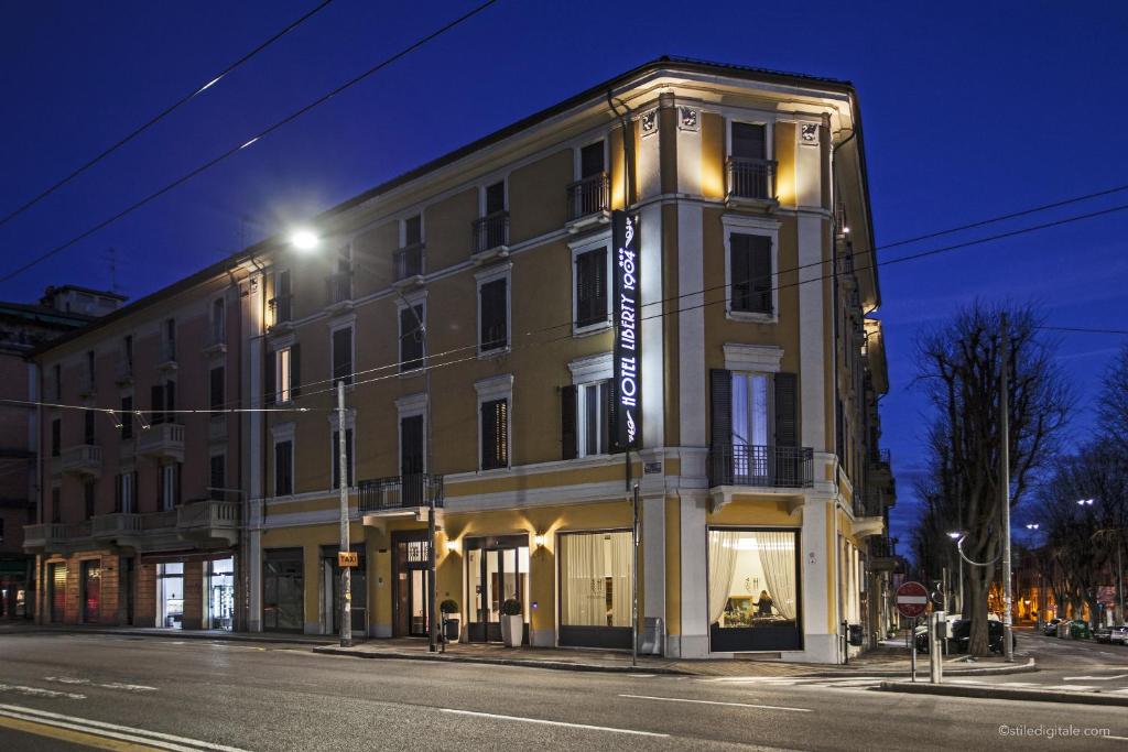 a large building on a city street at night at Boutique Hotel Liberty 1904 in Bologna