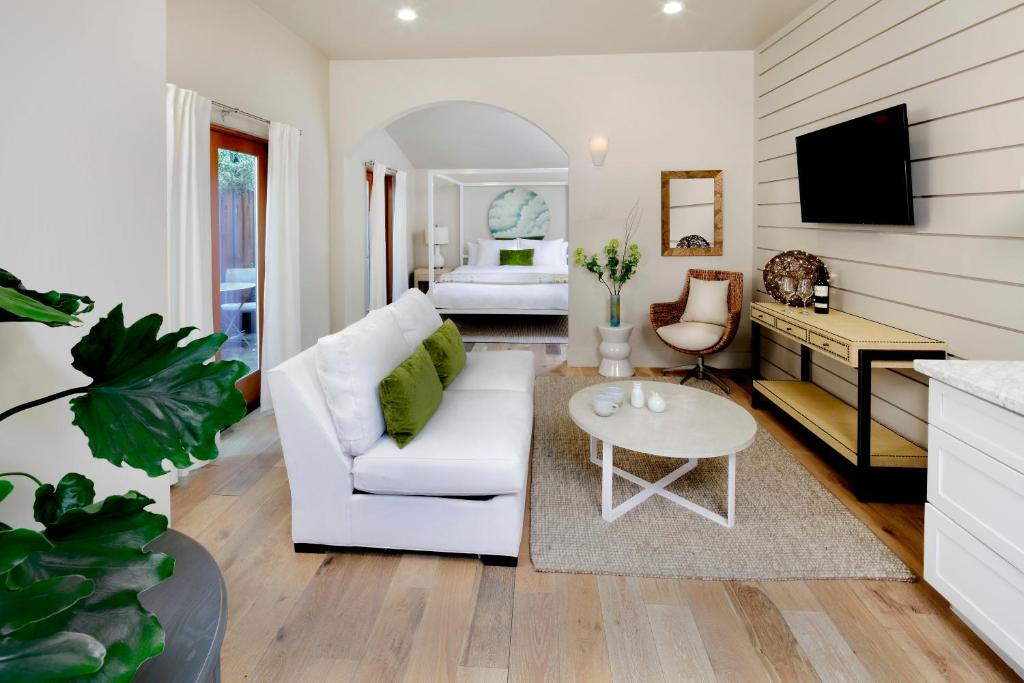a living room with a white couch and a bed at Rockhouse Suites in Healdsburg