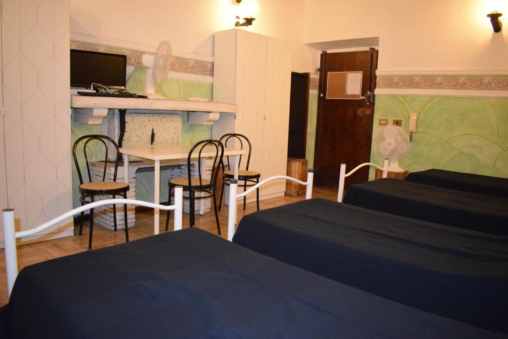 una camera con due letti e un tavolo con sedie di Rose Santamaria Residence a Roma