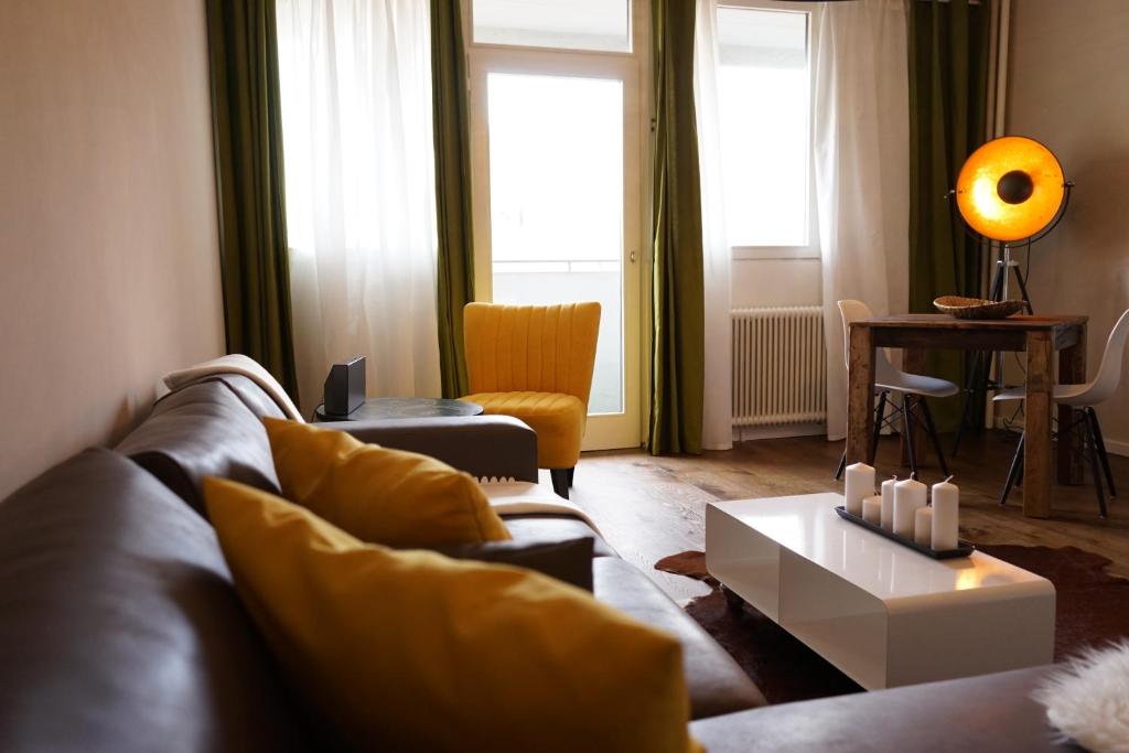 ein Wohnzimmer mit einem Sofa und einem Tisch in der Unterkunft Stylish New City Appartement in Graz