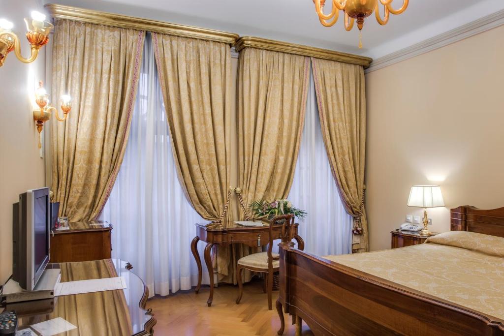 En eller flere senger på et rom på Villa Fenaroli Palace Hotel